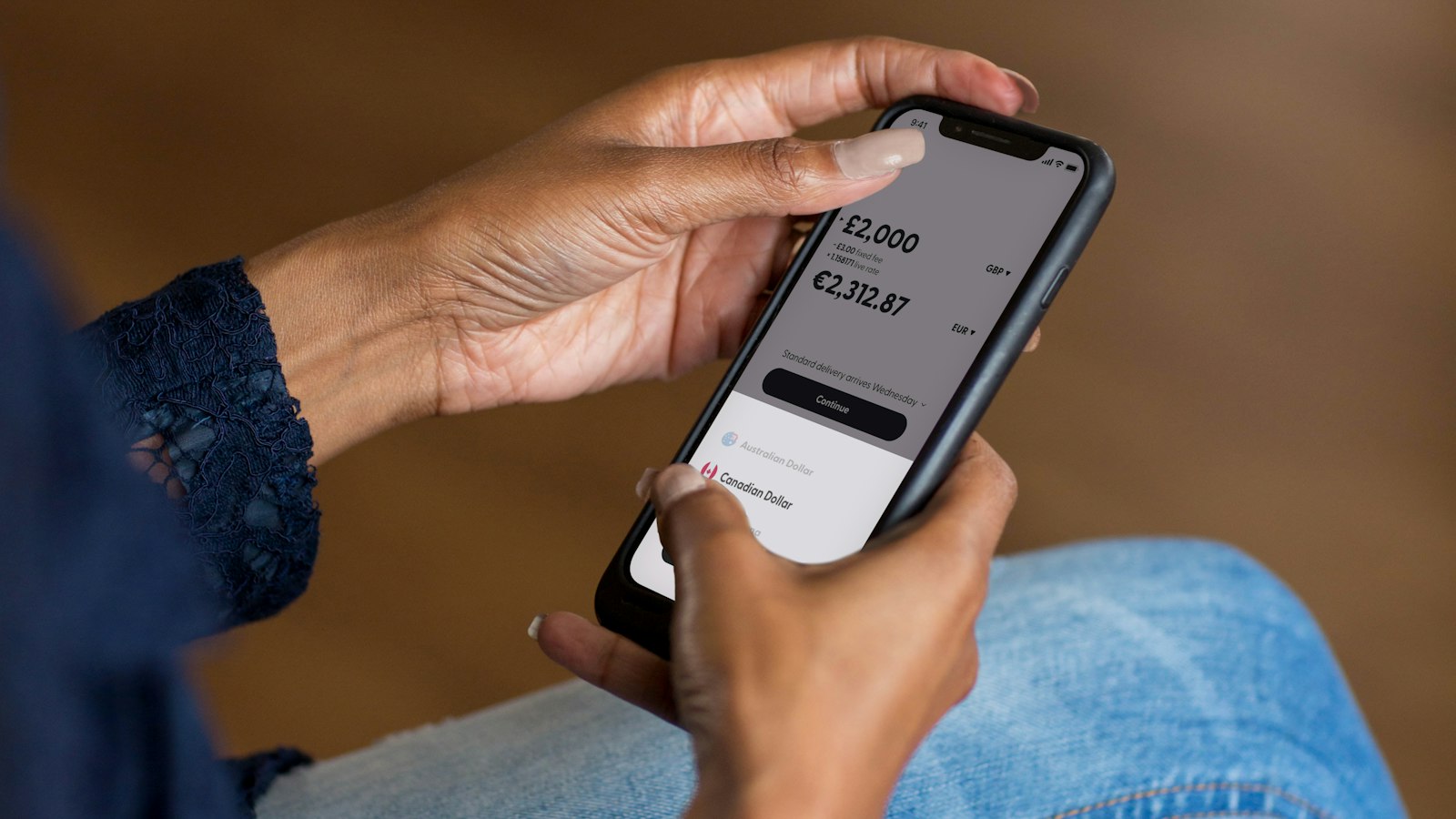 Customer holding a smartphone and confirming a transfer in a mobile banking app