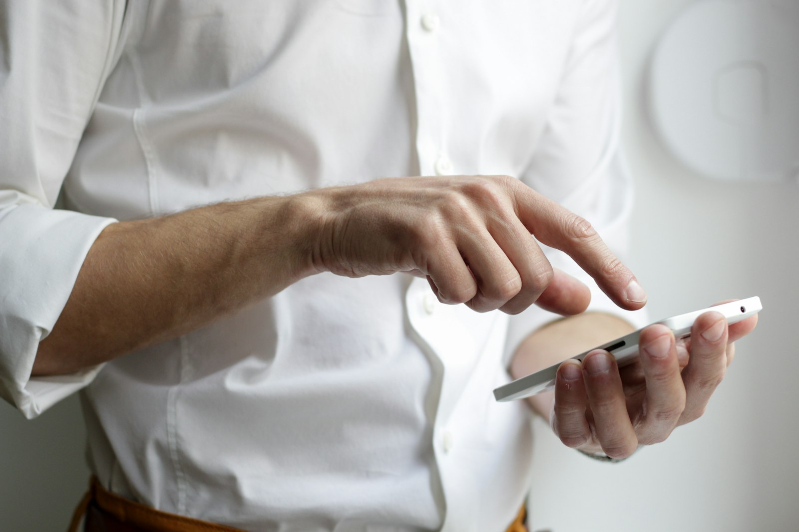 Businessperson in a white shirt using a smartphone